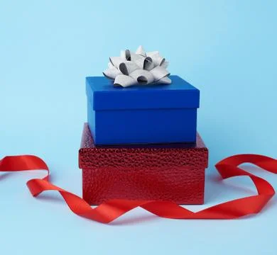 Stack of wrapped gifts with knotted bows on a blue background 스톡 사진