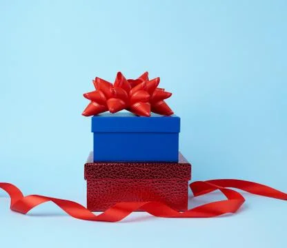 Stack of wrapped gifts with knotted bows on a blue background 스톡 사진