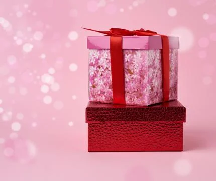 Stack of wrapped gifts on a pink background with bokeh Stockfoto's
