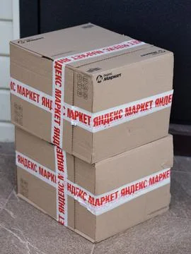 Stack of a Yandex Market cardboard boxes on the doorstep of a house Stock Photos