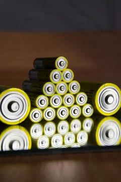 Stack of yellow AA batteries close up, electricity storage concept Stock Photos