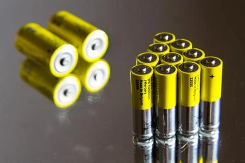 Stack of yellow AA batteries close up, electricity storage concept Stock Photos