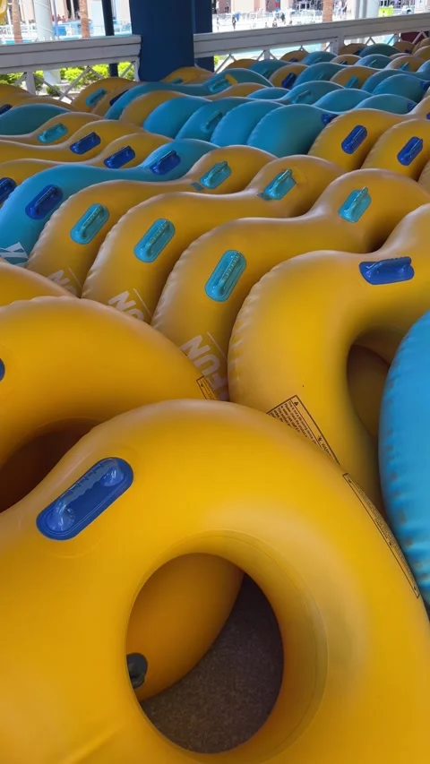 Stack of yellow and blue inflatable swimming tubes at a water park on June 20, Stock Footage 337292546
