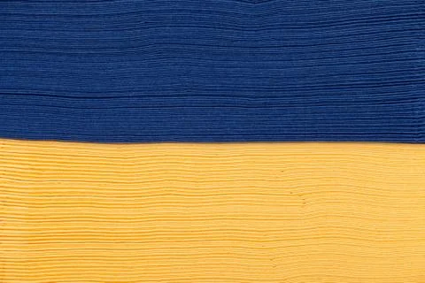 Stack of yellow and blue napkin paper closeup texture. Stock Photos