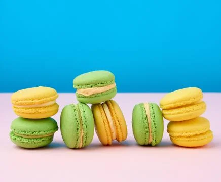 Stack of yellow and green round almond flour cakes macarons with cream on a b Stock-Fotos