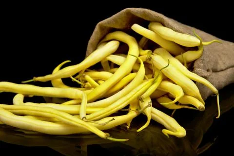 Stack of yellow beans in linen sack on black background Stock Photos