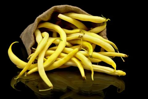 Stack of yellow beans in linen sack on black background Stock Photos