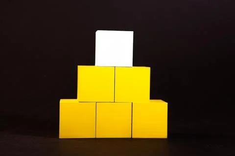 Stack of yellow cubes with blank card on black background, business concept 스톡 사진