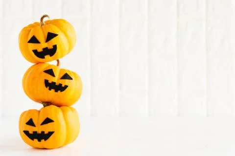 Stack of yellow ghost pumpkin on white brick block background. halloween conc Stock Photos