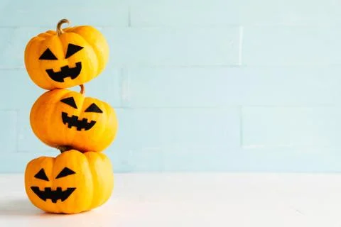 Stack of yellow ghost pumpkin on white brick block background. halloween conc Stock Photos