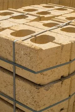 Stack of yellow limestone bricks secured with straps for construction build.. Stock Photos
