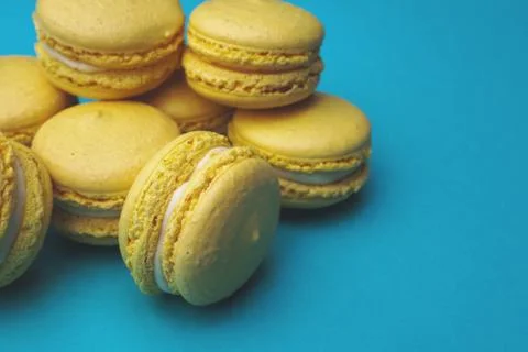 Stack of yellow macaroons on blue background. Stock Photos