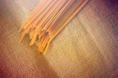 Stack of yellow spaghetti stick on sackcloth background Stock Photos