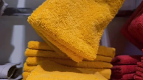 Stack of yellow terry towels neatly folded in a store. Video stock 300299701