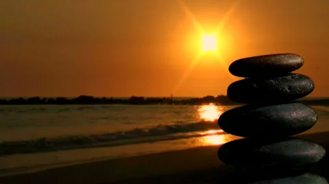 Stack of Zen rocks against ocean sunset - HD Stock Footage 569799
