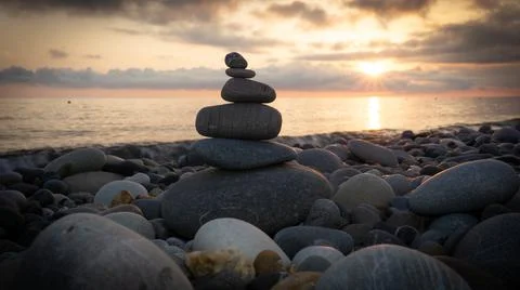 Stack of zen stones on the beach at sunset, beautiful seascape. Made of stone Stock Photos