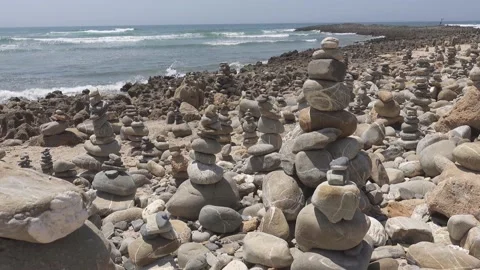 Stack of zen stones covering a big part of beautiful sand beach. Waves hittin Stock Footage 151112533