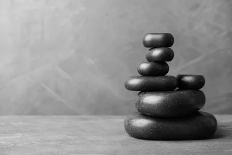 Stack of zen stones on table against grey background. Space for text 스톡 사진
