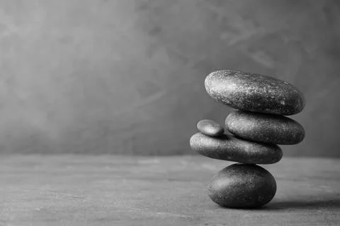 Stack of zen stones on table against grey background. Space for text Foto stock