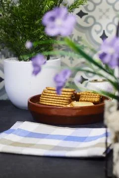 Stacked Biscuits in Ceramic Bowl on Kitchen Table with Potted Plant and Purple F Stock Photos