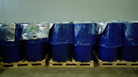 Stacked blue drums wrapped in silver liners on wooden pallets Video stock 347964612