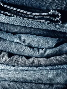 Stacked blue jeans using as background Stock Photos