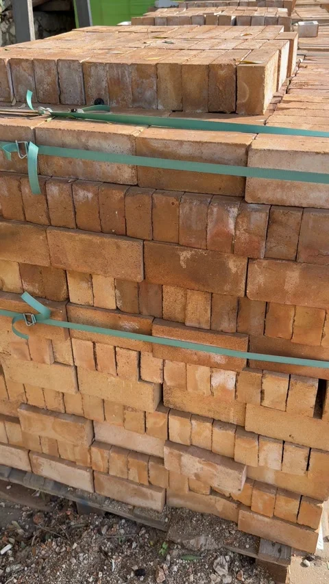 Stacked bricks tightly bound with green straps, ideal for construction and .. Stock Footage 326404587