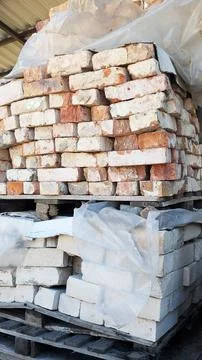 Stacked bricks in various colors and textures are neatly arranged on wooden Stock Photos
