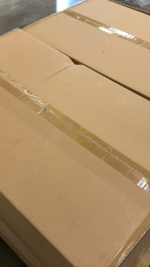 Stacked brown cardboard shipping boxes displayed on retail store shelves for Stock Footage 345172429