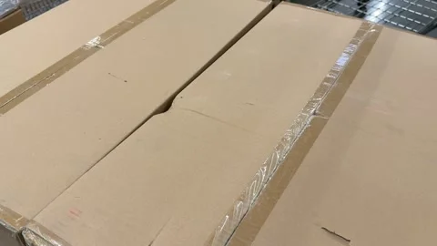 Stacked brown cardboard shipping boxes displayed on retail store shelves for Stock Footage 345181870