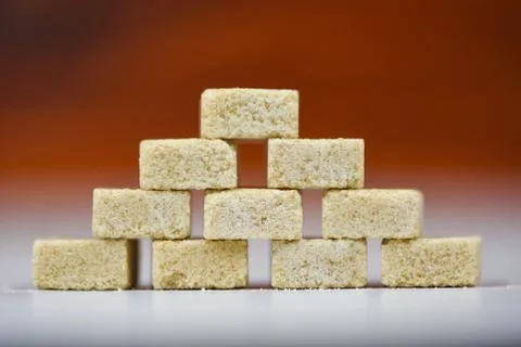 Stacked of brown sugar cubes on table background - Close up sugar Stock Photos
