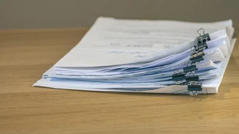 Stacked business documents secured with binder clips Stock Photos
