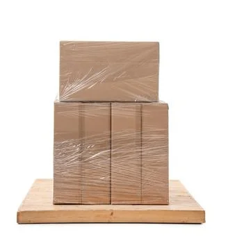 Stacked cardboard boxes wrapped in plastic film on wooden pallet, shipping an Stock Photos