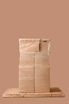 Stacked cardboard moving boxes wrapped in plastic on wooden pallet, shipping  Stock Photos