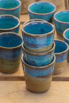 Stacked ceramic cups close up blue glazed handmade pottery on wooden table .. Foto stock