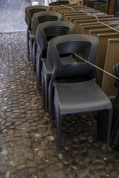 Stacked chairs and frames on a cobbled street in Bologna 库存照片