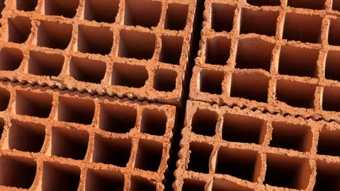 Stacked clay bricks showing rectangular hollow patterns, ideal for construc.. Stockbeeldmateriaal 330536644