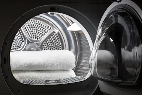 Stacked clean white towels inside washing machine drum. Clean concept. Laundr Stock Photos