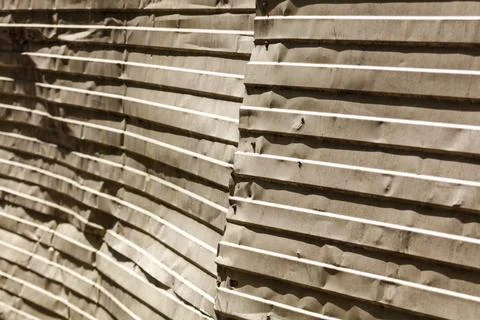 Stacked corrugated sheets of aged, beige-toned paper material Stock Photos