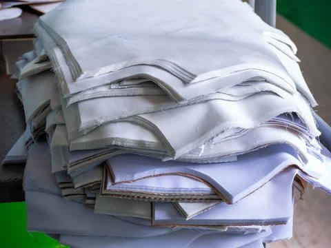 Stacked Cut White Fabric Pattern Pieces in Garment Factory Stock Photos