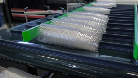 Stacked empty polypropylene cups on conveyor belt of plastic cup making machine Stock Footage 275153175
