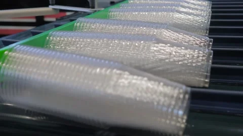 Stacked empty polypropylene cups on conveyor belt of plastic cup making machine Stock Footage 285348529