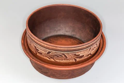 Stacked empty red clay pot and roaster on gray background Stock Photos