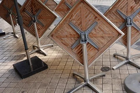 Stacked empty restaurant tables after service on the city streets Stock Photos