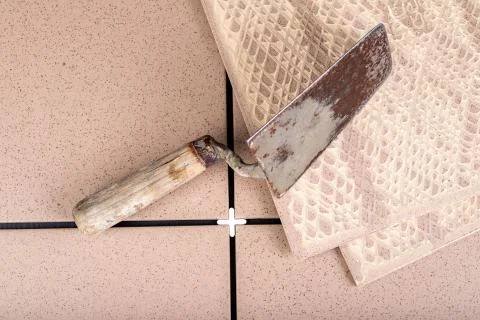 Stacked gres tiles. Old trowel for applying mortar. Stock Photos