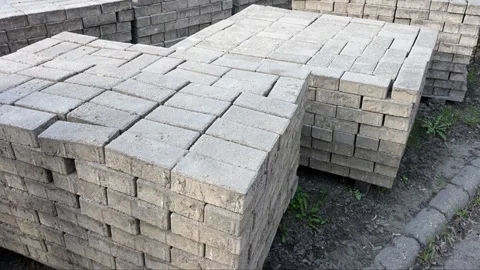 Stacked grey concrete paving blocks on wooden pallets Stock Footage 331583532