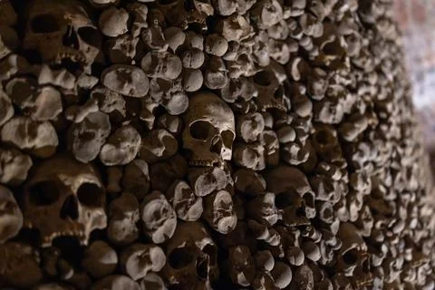 Stacked human skulls form a dense, ancient, eerie arrangement Stock Photos