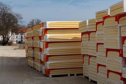 Stacked insulation boards in packages at a construction site. Stockfoto's