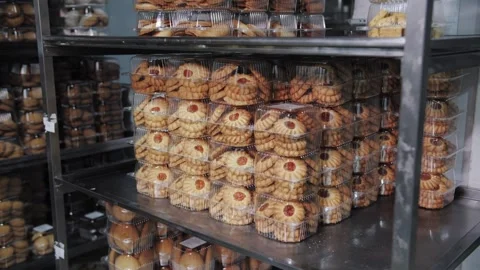 Stacked Jam-Filled Cookies Packaged on Metal Shelves. Bakery production Stock Footage 321808580