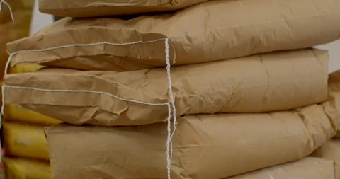 Stacked kraft paper sacks on cardboard pallet with visible twine and flour sack Stock Footage 344595612